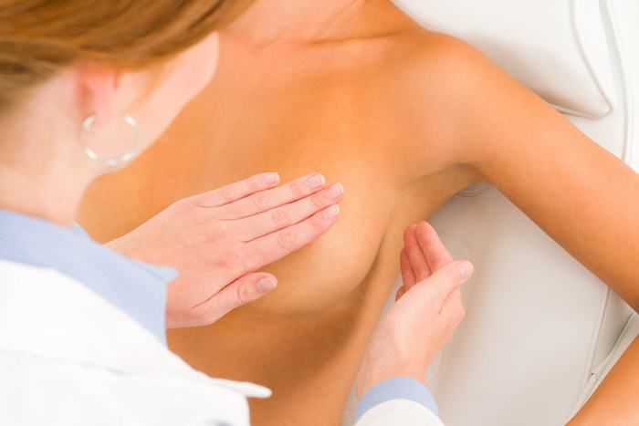 врач осматривает грудь женщины